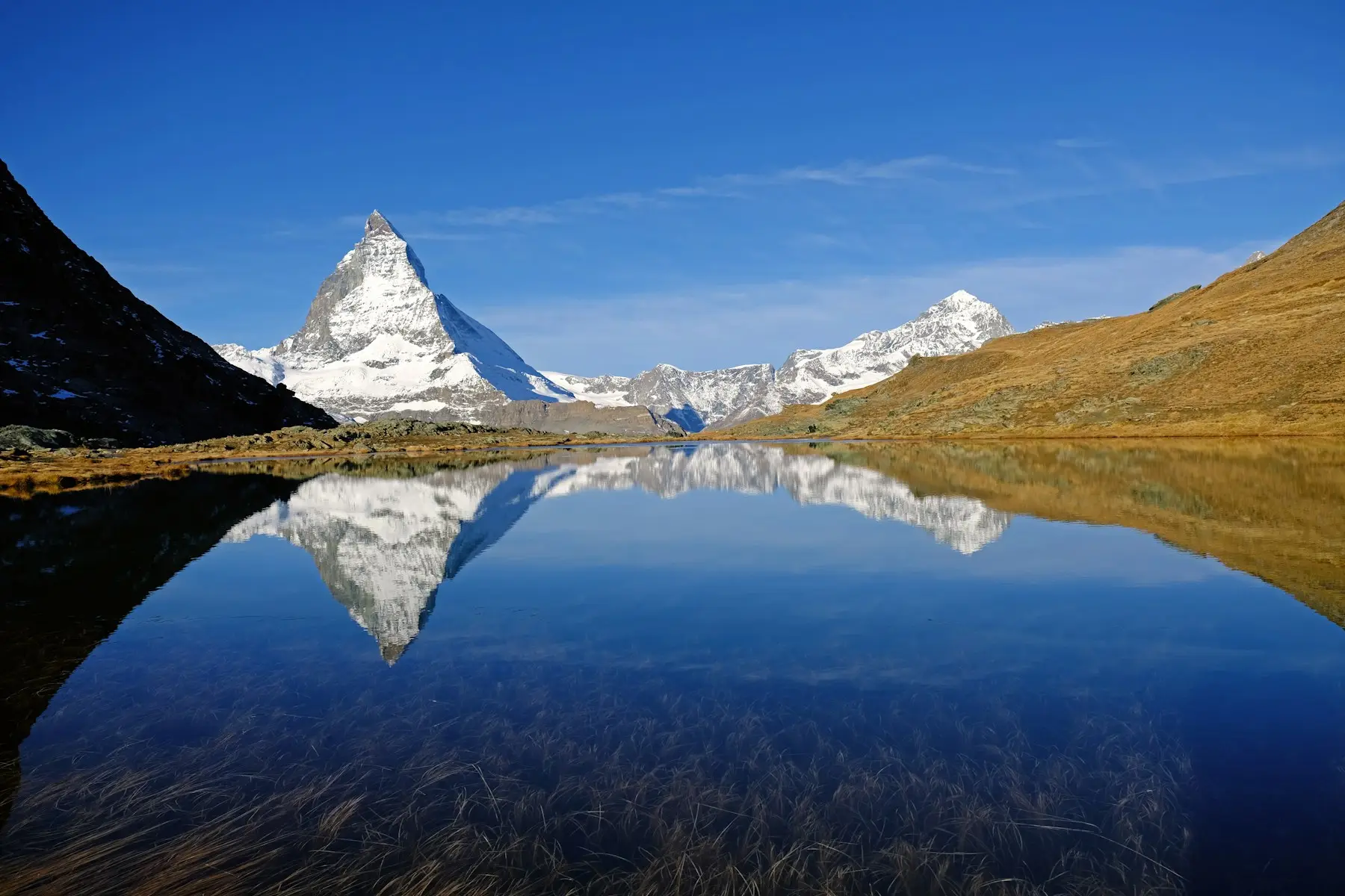 Montanha nevada refletida em lago nos Alpes suíços
